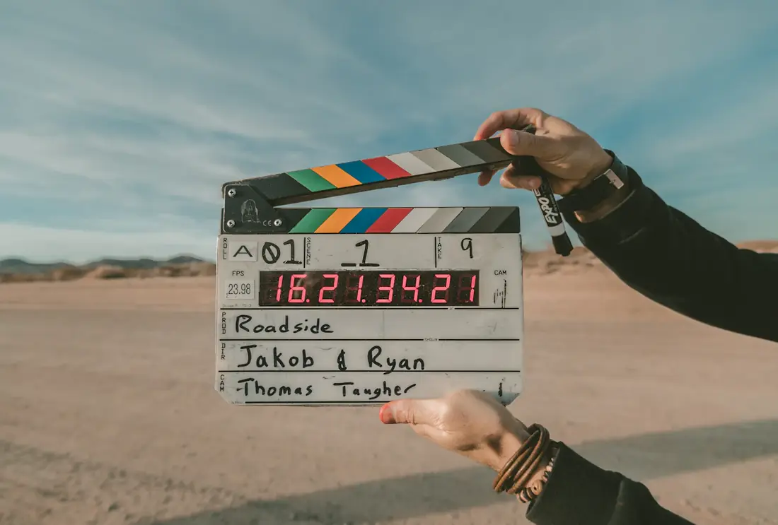 A clapperboard held up against a desert sky