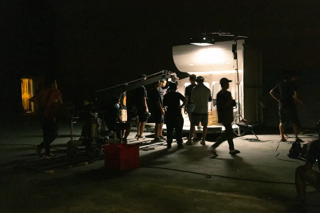 A night shoot lit by one lamp with the crew gathered nearby